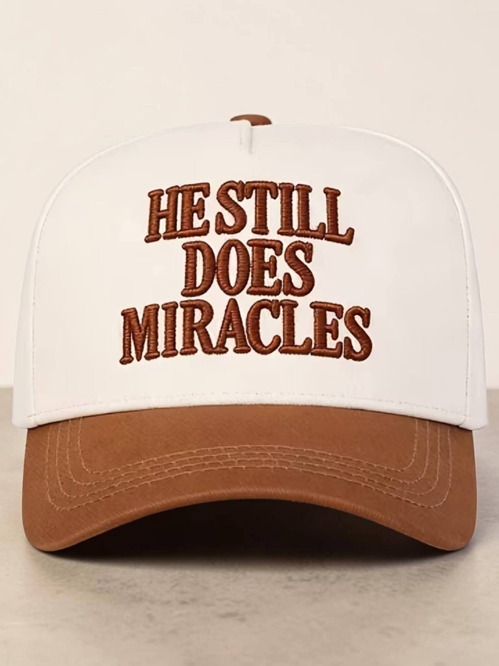 White and Brown Trucker Hat with "He Still Does Miracles" Embroidery
